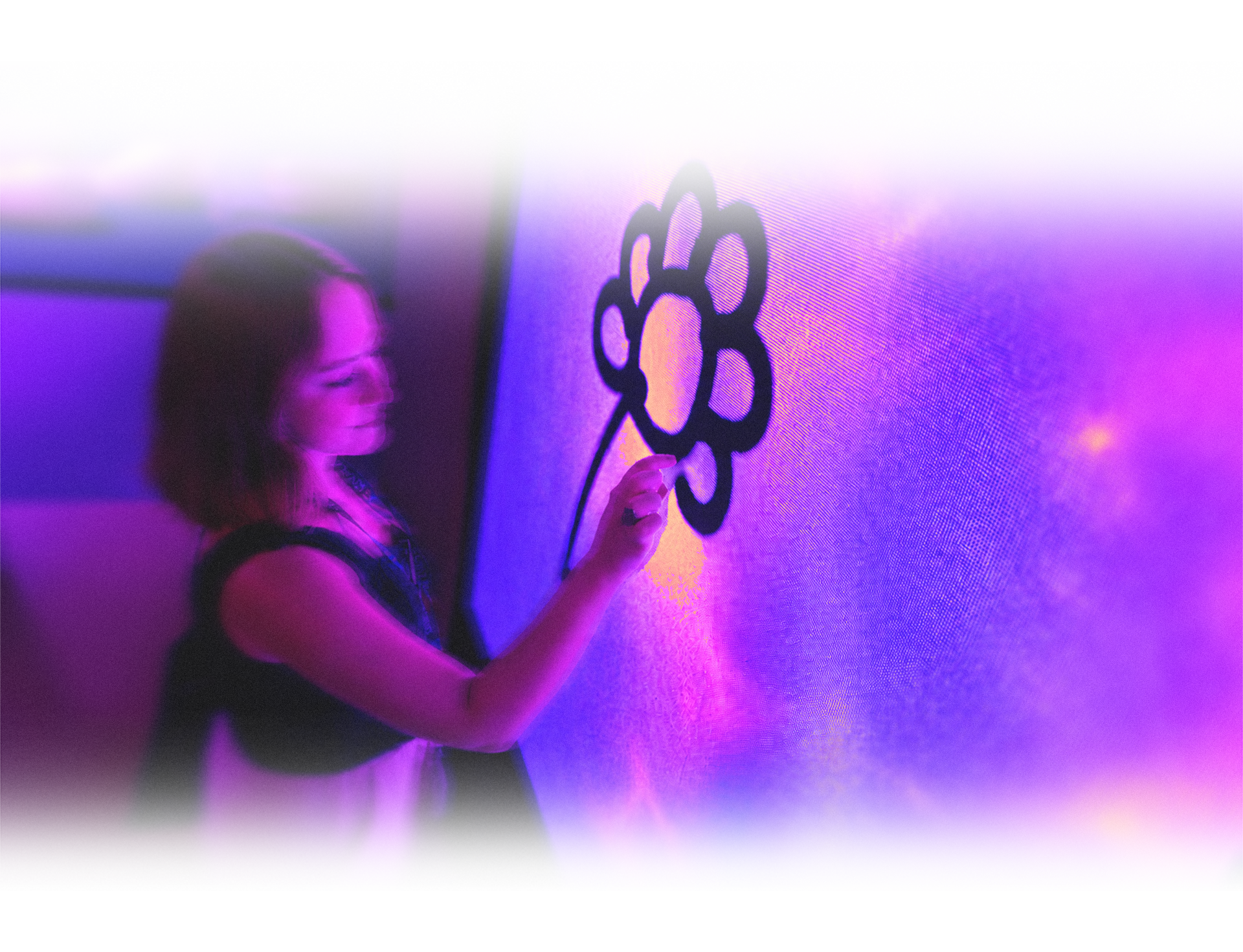 Person beside a large magenta-lit wall in a dark space