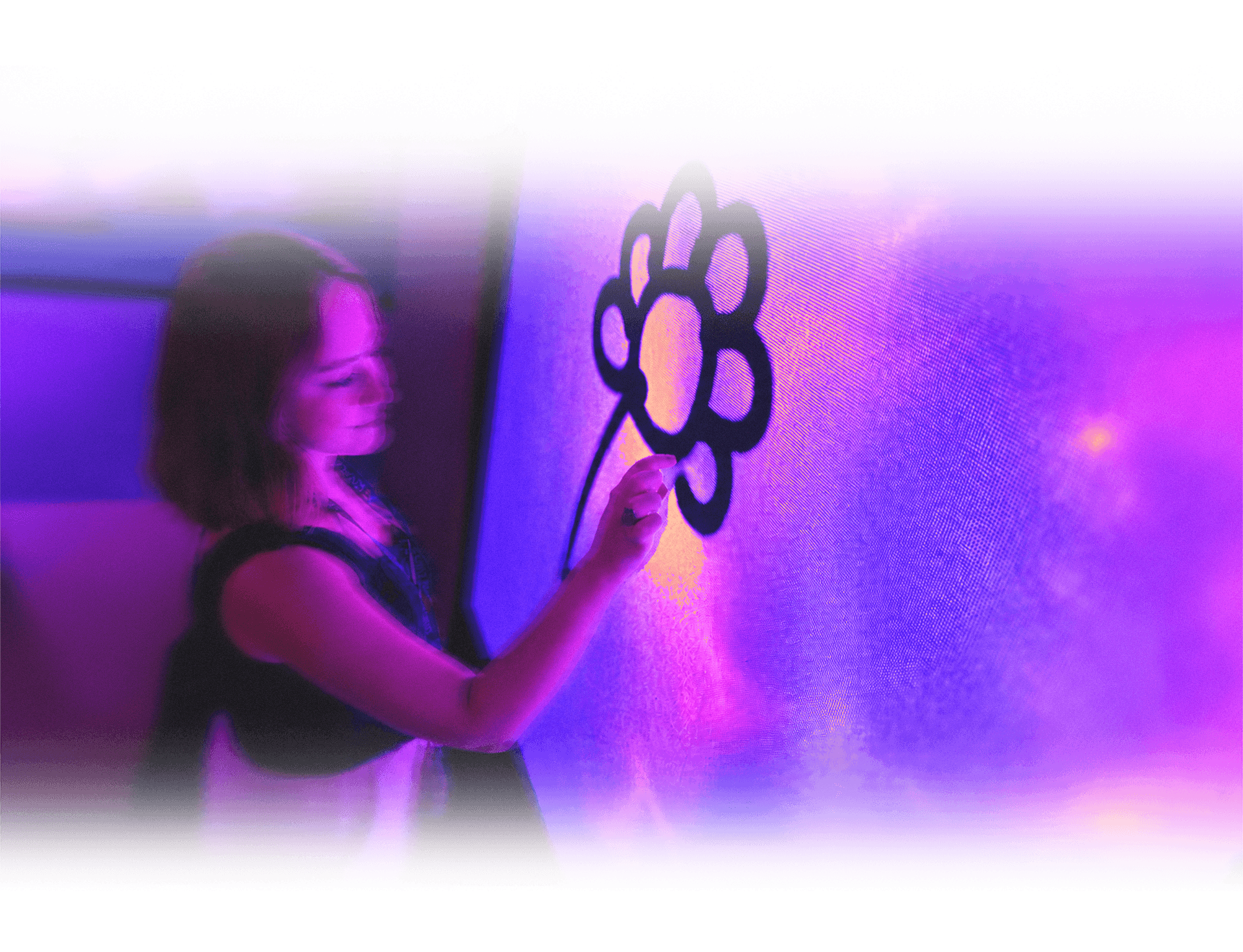 Person beside a large magenta-lit wall in a dark space